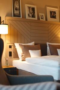 Romantik Hotel Kieler Kaufmann في كيل: سريرين في غرفة الفندق مع اللوح الأمامي