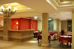 a restaurant with red walls and tables and chairs at Hotel Savoia Mendoza in Guaymallen