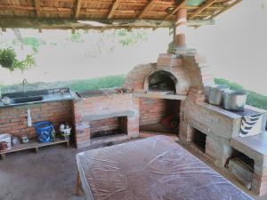un horno de ladrillo al aire libre con fregadero y mesa en Sítiio São Miguel projeto agroecológico en Caconde