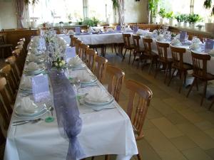 einen langen Tisch mit weißen Tischen und Stühlen in einem Zimmer in der Unterkunft Gasthof Rhönperle in Kothen