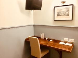 d'une table à manger avec une télévision murale. dans l'établissement Aragonese Luxury Rooms, à Naples