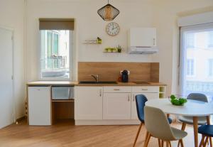a kitchen with a table and a sink and a table and chairs at Studio Liberté Plein Centre in Saint-Raphaël