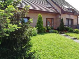 une maison avec une cour verdoyante devant elle dans l'établissement Chambre plein comfort, à Vimy