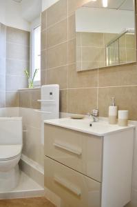 a bathroom with a white sink and a toilet at Studio Liberté Plein Centre in Saint-Raphaël