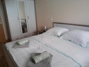 a white bed with two towels and a mirror at Apartments Juliet in Orebić