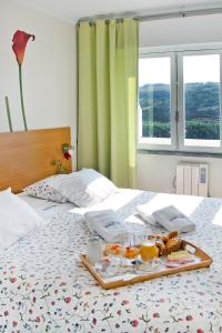 a tray of food sitting on top of a bed at Sintra Sol - Apartamentos Turisticos in Sintra