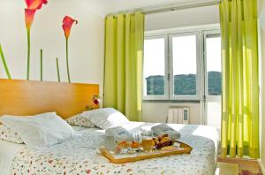 a tray of food on a bed in a bedroom at Sintra Sol - Apartamentos Turisticos in Sintra