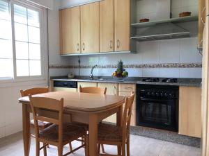 a kitchen with a wooden table and chairs and a stove at La casa de Perfecta in Gondomar