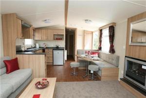 a kitchen and living room with a couch and a table at Pine drive in Mablethorpe