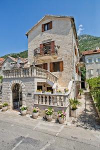 een stenen gebouw met potplanten ervoor bij Hotel Admiral in Perast