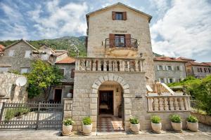 een groot stenen gebouw met een gewelfde ingang bij Hotel Admiral in Perast