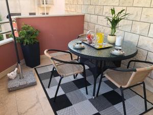una mesa con dos sillas y una mesa con bebidas. en Rooms Ana en Split