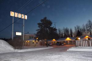 a street sign in front of a motel in the snow at Motel Marie-Dan in Sainte-Eulalie
