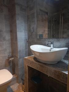 a bathroom with a white sink and a toilet at Modern sea view appartment in Artemida