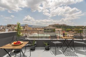 einen Balkon mit Tischen und Stühlen und Aussicht in der Unterkunft Downtown Boutique Apartments Acropolis View in Athen