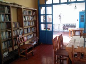 a library with book shelves filled with books and a table at Hotel Santa Prisca in Taxco de Alarcón