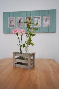 博爾庫姆的住宿－Dünenhus Borkum，一张桌子上装有粉红色花的花瓶