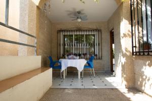 un patio con una mesa blanca y sillas azules en MOLINO 7 en Carboneras