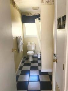 薩科的住宿－Exit 5 Resort & Condominium，一间带卫生间和 ⁇ 格地板的浴室
