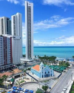 uma vista para uma cidade com um edifício e o oceano em Apartamento Boa Viagem no Recife