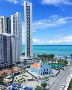 a view of a city with a building and the ocean at Apartamento Boa Viagem in Recife