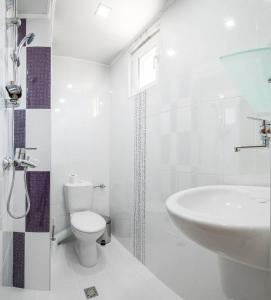 La salle de bains blanche est pourvue de toilettes et d'un lavabo. dans l'établissement Guest House Galema, à Obzor