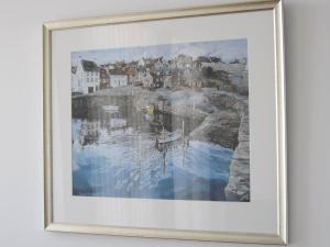 a framed painting of a town on the water at Bridge Street Apartments in Inverness