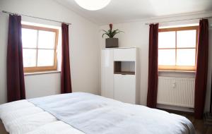 1 dormitorio con 1 cama blanca y 2 ventanas en Altstadt Ferienwohnung An Der Stadtmauer en Füssen