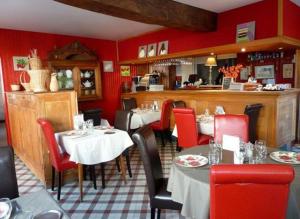 a restaurant with tables and chairs and red walls at Le Clos d'Ussé in Rigny-Ussé