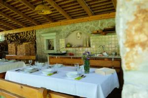 a table with a white table cloth in a kitchen at Happy River House in Kamna Gorica