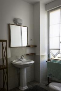 ein Bad mit einem Waschbecken und einem Spiegel in der Unterkunft Comme à la Breizhon in Penmarcʼh