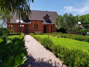 a house with a brick path in front of a house at Villa "GREEN PARADISE" in Divjakë