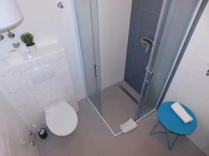 a bathroom with a shower and a toilet and a stool at Apartman Karmen in Tučepi