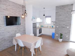 a kitchen and dining room with a table and chairs at Apartman Karmen in Tučepi
