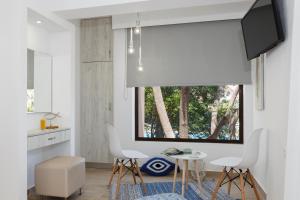 a kitchen with a table and chairs and a window at Lyristis Dinos Studios & Apartments in Faliraki