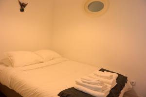 um quarto com uma cama com lençóis brancos e toalhas em Sostoa Studio Porto, by Flat in Porto no Porto