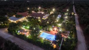 an aerial view of a house with a swimming pool at night at Villa Ghetta Country House in Leverano +32 photos