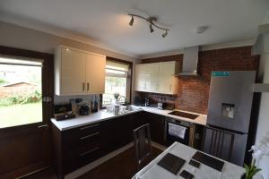 una cucina con mobili bianchi e un muro di mattoni di Lasswade Road House a Edimburgo Altre 12 foto