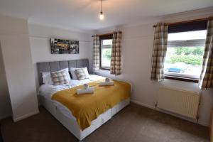 una camera da letto con un letto e due finestre di Lasswade Road House a Edimburgo