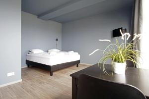 Un dormitorio con una cama y una mesa con una planta en Iceland Comfort Apartments by Heimaleiga, en Reikiavik