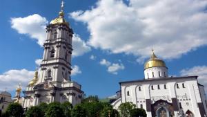 a building with two towers with gold roofs at Family House Nichka in Pochayiv +8 photos