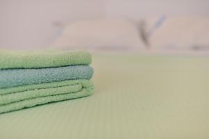 une pile de serviettes vertes posées sur un comptoir dans l'établissement Apartman Svilno, à Rijeka 62 autres photos