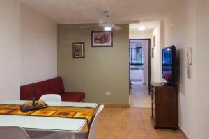 ein Wohnzimmer mit einem Sofa und einem TV in der Unterkunft Ashram in San Miguel de Tucumán