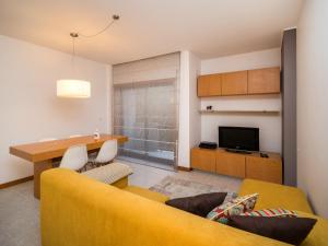 a living room with a yellow couch and a table at Susanna in Viana do Castelo