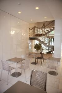 a dining room with tables and chairs and a staircase at Hotel Costa Verde in Póvoa de Varzim