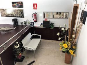 una oficina con escritorio, silla y flores en Apartamentos Puerto Basella, en Villanueva de Arosa