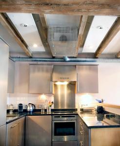 eine Küche mit Küchengeräten aus Edelstahl und einer Decke in der Unterkunft Apartment 3, Warehouse K in London