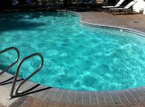 a pool of blue water with chairs in it at Mammoth Mountain Inn in Mammoth Lakes