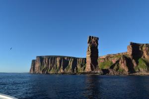 a view of a cliff from a boat in the water at Sanderlay Guest House in Kirkwall