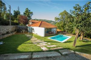 een achtertuin met een zwembad en een huis bij Casa da Assudra in Vila Verde